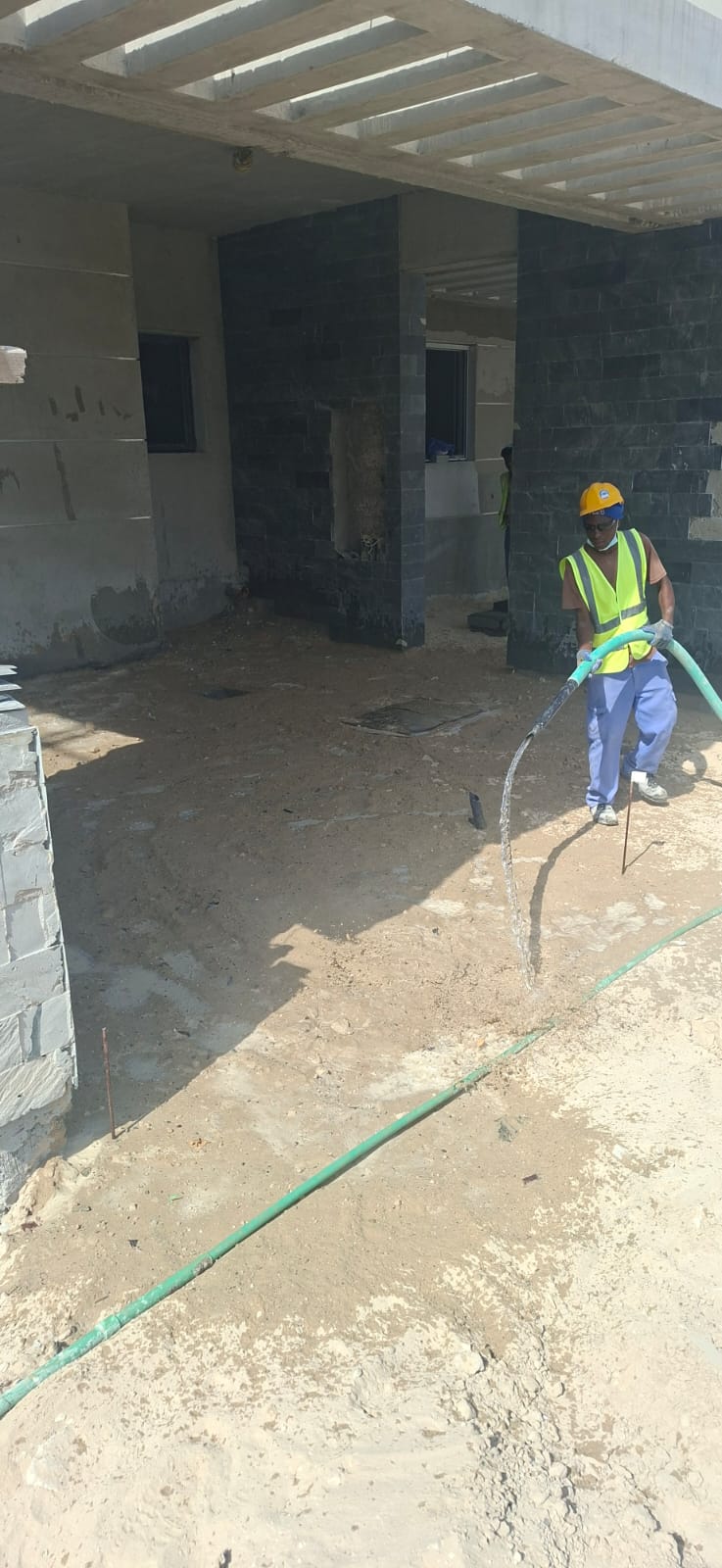 Worker applying finishes to stone-clad building facade