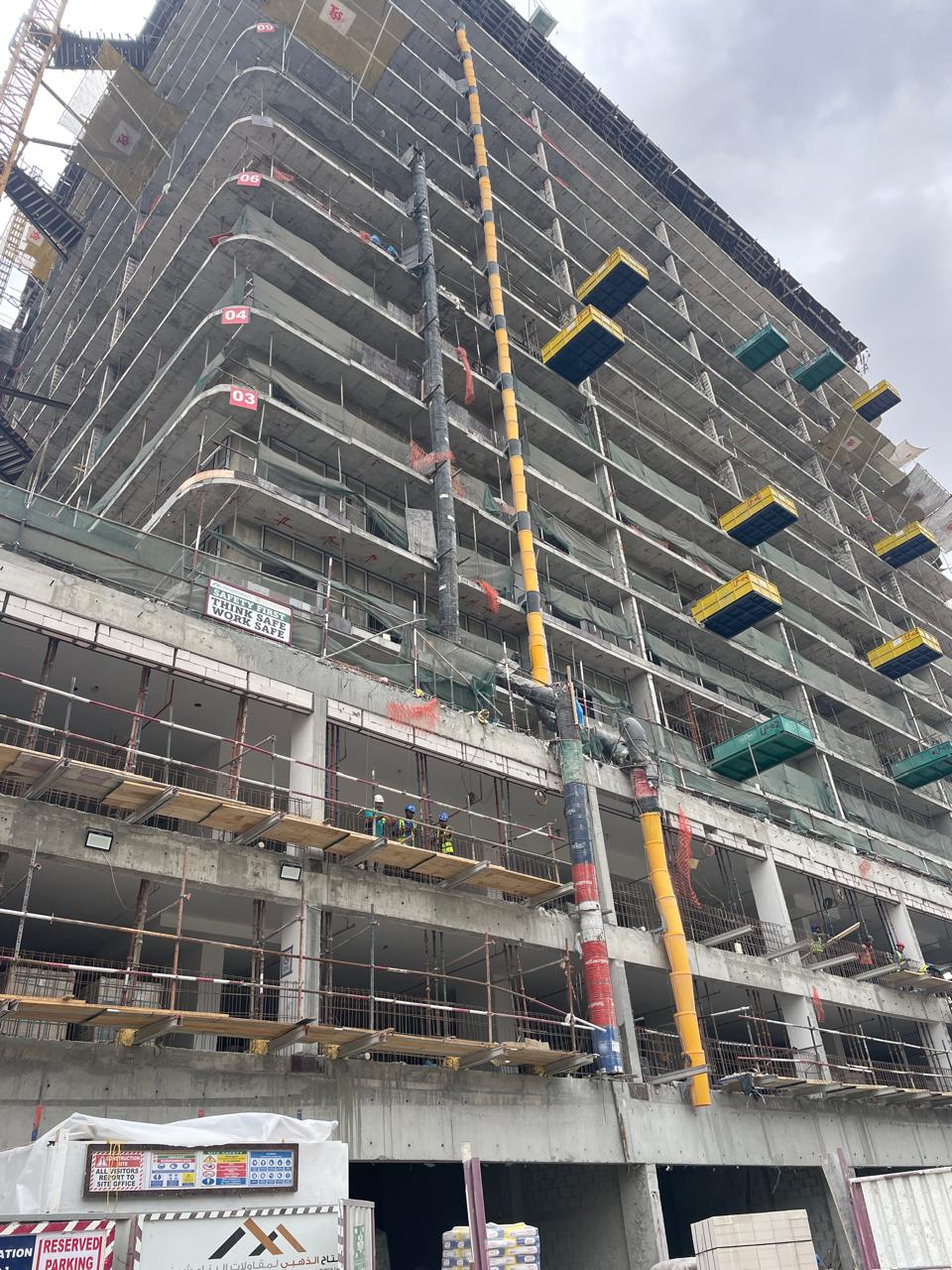 High-rise tower under construction with scaffolding and safety netting